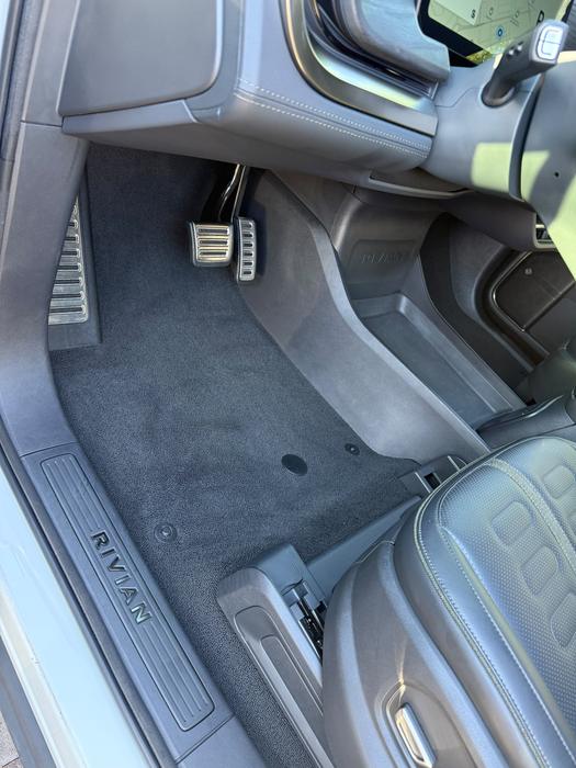 Rivian R1S driver footwell with shampooed carpet and cleaned pedals