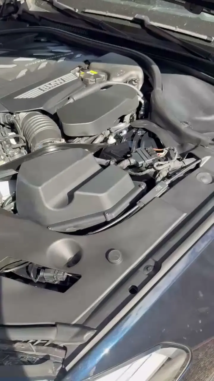 Finished BMW engine bay with the covers and plastics clean after the detail