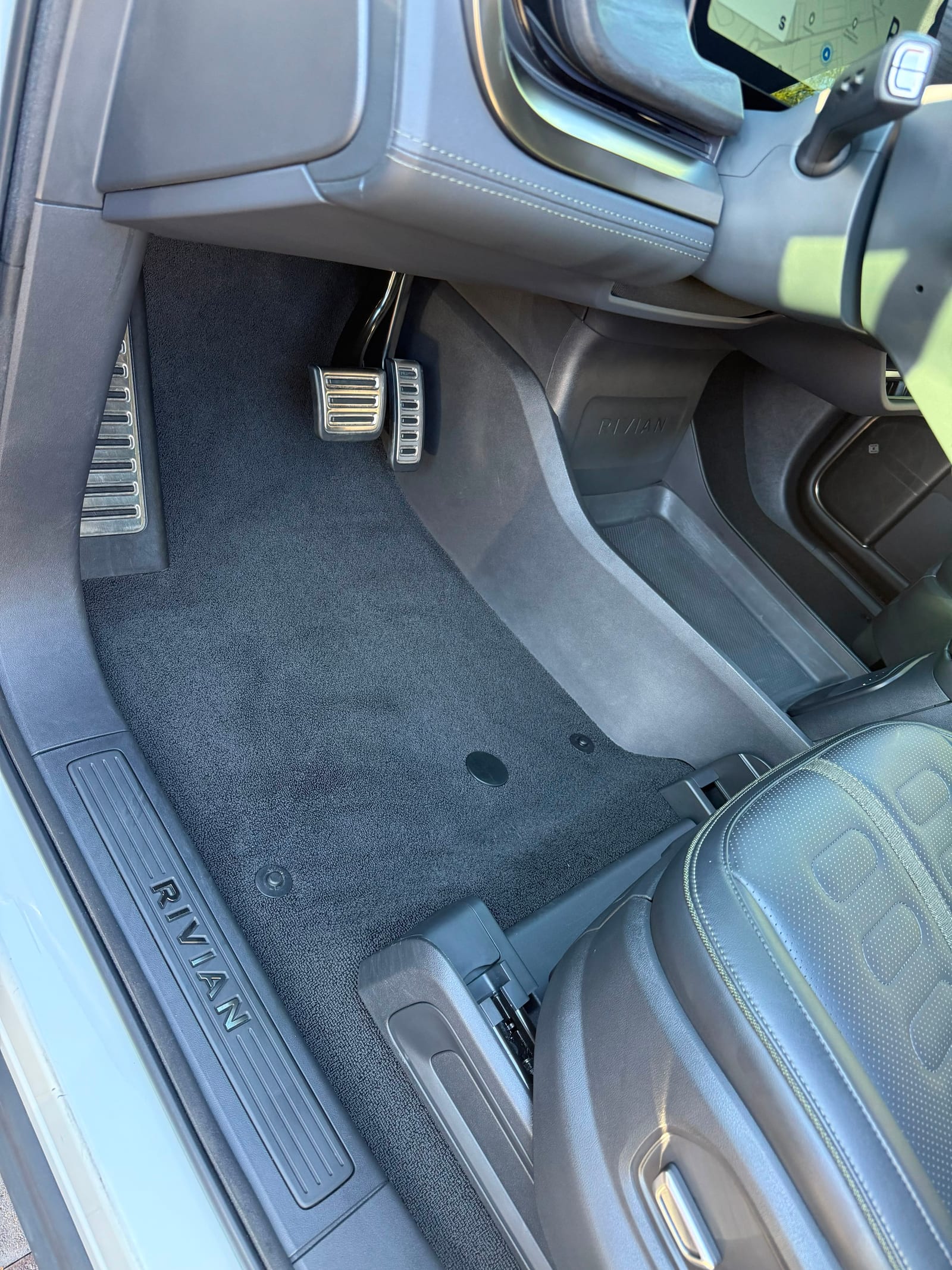 Rivian R1S driver footwell, pedals and sill plate cleaned during an interior detail
